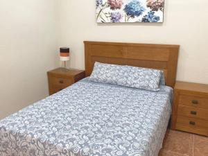 1 dormitorio con 1 cama con edredón azul y blanco en Apartamento Terraza Arenales del Sol en Arenales del Sol