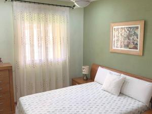 1 dormitorio con cama blanca y ventana en Apartamento Terraza Arenales del Sol en Arenales del Sol
