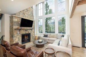 sala de estar con chimenea de piedra y TV en Overlook House home en Telluride