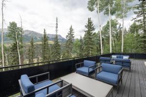 a deck with chairs and tables and a view of the mountains at Overlook House home in Telluride