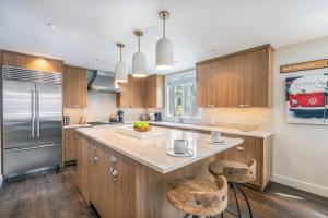 a kitchen with wooden cabinets and a kitchen island with stools at 330 W Pacific B townhouse in Telluride
