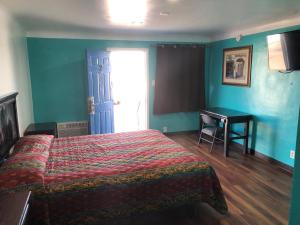 a bedroom with a bed and a desk in it at Star Motel in Norwalk