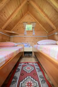 a room with two beds in a wooden house at Camp &Apartmens Scepanovic in Mojkovac
