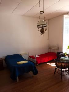 1 dormitorio con 2 camas y 1 cama roja en Casa Pellegrini - Hostel en San Pedro