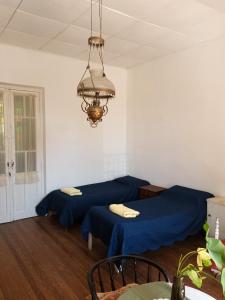 Habitación con 2 camas y lámpara de araña. en Casa Pellegrini - Hostel en San Pedro