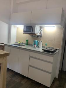 uma cozinha com armários brancos e uma bancada em Sweet Home em Vicente López