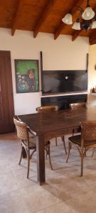 a wooden table with chairs and a piano in a room at MI CASA in El Calafate