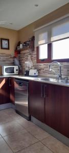 a kitchen with a sink and a stove at MI CASA in El Calafate