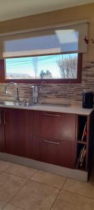 a kitchen counter with a sink and a window at MI CASA in El Calafate