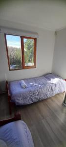 um quarto com uma cama e uma janela em MI CASA em El Calafate