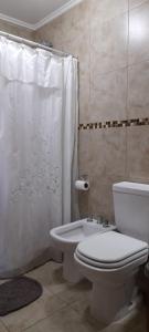 a bathroom with a toilet and a shower and a sink at MI CASA in El Calafate