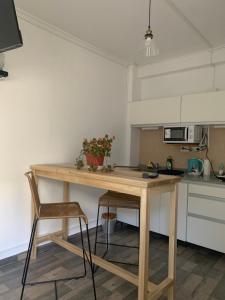 a kitchen with a wooden table and two chairs at Sweet Home in Vicente López