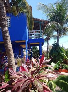 una casa azul con palmeras y plantas en VILLA com Wi-Fi, cozinha, parking, Canoa Quebrada zona centro, jardim tropical, tudu prossimo a pe, en Canoa Quebrada