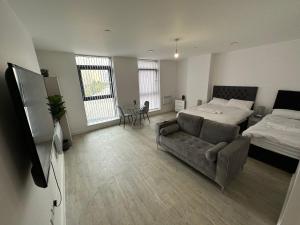 a living room with a bed and a couch at Manchester Old Trafford Studio Apartment in Manchester