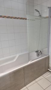 a white bath tub with a faucet in a bathroom at Moulins F3 hyper centre de Saint Dizier in Saint-Dizier