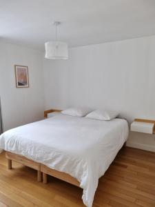 a white bed with white sheets and pillows at Moulins F3 hyper centre de Saint Dizier in Saint-Dizier