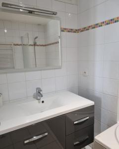 a white bathroom with a sink and a mirror at Moulins F3 hyper centre de Saint Dizier in Saint-Dizier