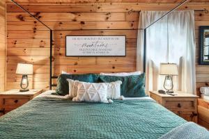 1 dormitorio con cama verde y pared de madera en Kate's Cabin - 3 min to Dollywood! Cabin with Hot tub, Game Room, and Resort Pool!, en Sevierville