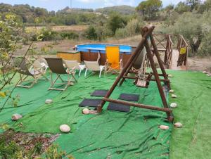 un parque infantil con sillas y una mesa sobre una manta verde en MAS GUILLO, en Sant Quintí de Mediona