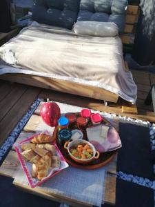 a tray of food on a table next to a bed at Chalet des secrets in Lyaud