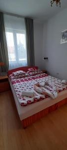 ヘーヴィーズにあるOrchidea Apartmanのベッドルーム1室(大型ベッド1台、赤と白のキルト付)