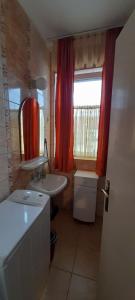 uma pequena casa de banho com um lavatório e um espelho em Orchidea Apartman em Hévíz