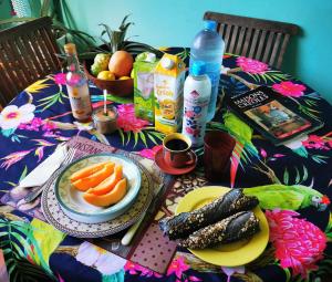 a table with a plate of food and fruits and vegetables at COLOCATION CITE URBAINE in Pointe-à-Pitre