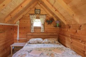 a bedroom in a log cabin with a bed at Camp &Apartmens Scepanovic in Mojkovac