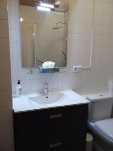 een badkamer met een wastafel, een spiegel en een toilet bij MAS GUILLO in San Quintín de Mediona
