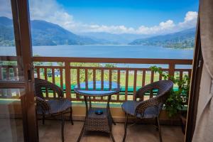 博卡拉Hotel Fewa Camp的带桌椅的阳台，可欣赏美景
