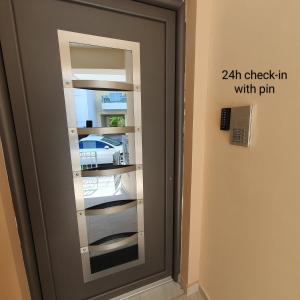 a glass door with a inch check in with pin at Volos Park Apartments in Volos