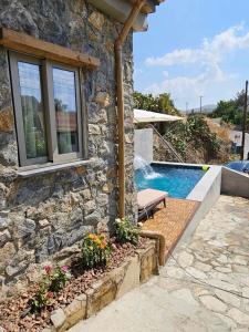 a stone house with a swimming pool next to a building at Jennas House in Arakapas