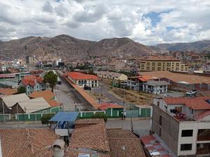 uitzicht op een stad met gebouwen en bergen bij Hostal Cactus in Cuzco