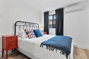 1 dormitorio con 1 cama, mesita de noche y ventana en Mid-Century Modern Dream Retreat en West Kelowna