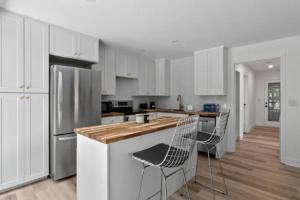 a kitchen with white cabinets and a wooden counter top at Mid-Century Modern Dream Retreat in West Kelowna