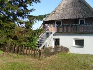 an old house with a thatched roof with a staircase at Alte Försterei in Mustin