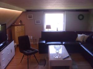 sala de estar con sofá de cuero negro y mesa en Alte Försterei, en Mustin
