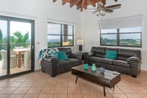 a living room with two couches and a table at Pineapple Villa 142 condo in Roatán
