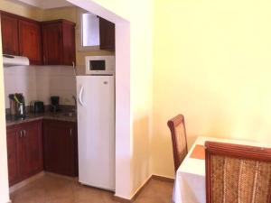 a kitchen with a white refrigerator and a microwave at El Dorado Condo 302A in Punta Cana
