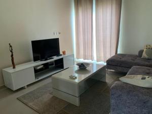 uma sala de estar com uma televisão e um sofá em Appartement à Residence de la Paix em Dakar