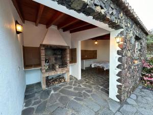 a patio with a stone fireplace in a house at Preciosa casa Canaria vista mar y montaña El encanto de Lita in Mazo