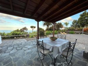 a table and chairs on a patio with a view of the ocean at Preciosa casa Canaria vista mar y montaña El encanto de Lita in Mazo