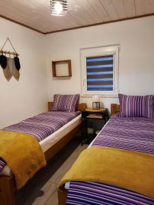 a bedroom with two beds and a window and a table at Bieszczadzka SielAnka in Ustrzyki Dolne