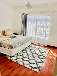 1 dormitorio con 1 cama con alfombra y ventana en Mont Pelaan 40, en Newcastle