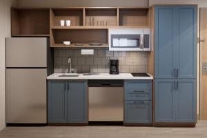 a kitchen with blue cabinets and a refrigerator at Candlewood Suites Atlanta - Smyrna, an IHG Hotel in Atlanta