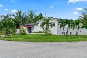 una casa blanca con palmeras delante en Miami Fun Home with Pool & Games L30, en Miami
