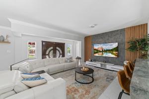 sala de estar con sofá blanco y TV en Miami Fun Home with Pool & Games L30, en Miami