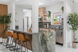 cocina con encimera de mármol grande y taburetes en Miami Fun Home with Pool & Games L30, en Miami