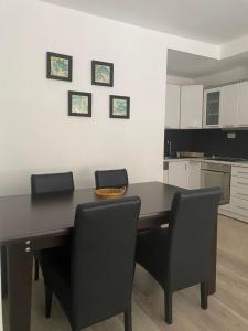 uma cozinha com uma mesa preta e cadeiras em Private Apartment Prishtina em Pristina