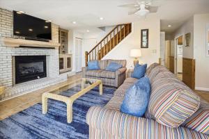a living room with a couch and a fireplace at 2816 - Tranquil Sound by Resort Realty in Duck